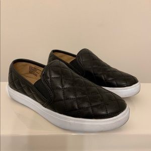 Black slip on sneakers, dirt stains on the bottom